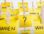 adhesive note papers with question mark and w questions hanging on the rope