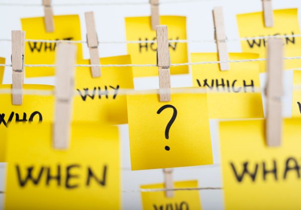 adhesive note papers with question mark and w questions hanging on the rope