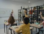 students raising hand in a classroom