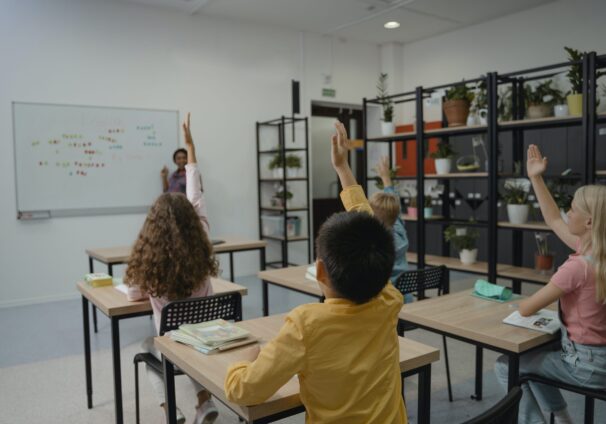 students raising hand in a classroom